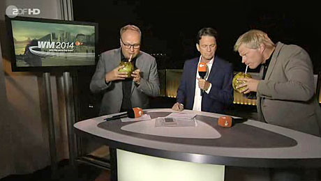 Oliver Welke und Oliver Kahn trinken von Rudi Cerne mitgebrachte Kokosnüsse aus